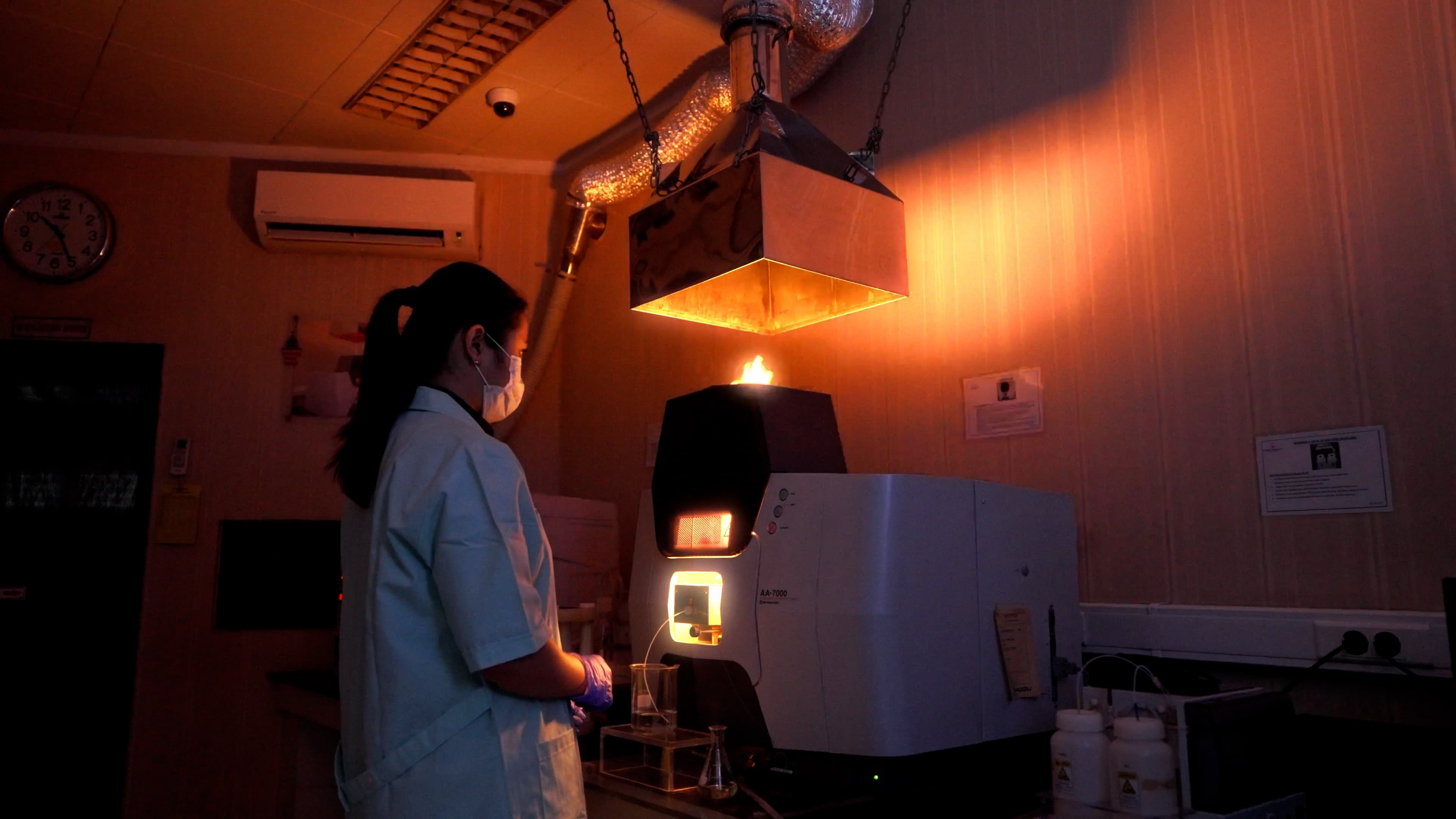 Laboratory analysts operating spectrometer equipment